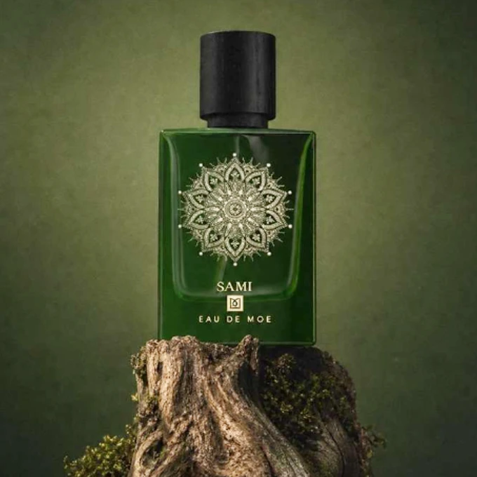 Sami Eau de Moe - Flacone poggiato su un legno, con sfondo verde
